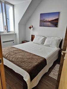 um quarto com uma cama grande e uma pintura na parede em Apartments Myna in Kraljevi Cardaci em Kopaonik