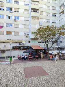 a group of people sitting at tables in front of a building at Telma Room in Mealhada