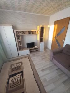 uma sala de estar com um sofá e uma televisão em Apartament cu 2 camere em Hunedoara