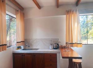 uma cozinha com um balcão, um lavatório e uma janela em La Casa de Damien em Urubamba