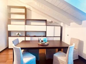 een eetkamer met een houten tafel en stoelen bij Casa Cambria in Como