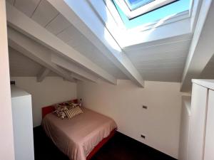 een slaapkamer met een bed op een zolder met een dakraam bij Casa Cambria in Como