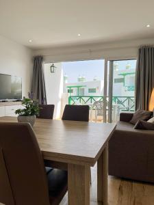 a dining room with a table and a couch at Beautiful Apartment Aguycan Beach 120 Playa del Aguila Maspalomas Gran Canaria in Maspalomas