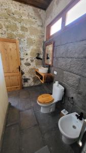 a stone bathroom with a toilet and a sink at El Batan Resort in Santa Brígida