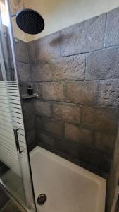 a bathroom with a shower with a stone wall at El Batan Resort in Santa Brígida