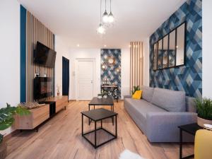 Una sala de estar con un sofá y un televisor. en ClairChêne - Cosy Centre Parking Spacieux Familial, en Verdún