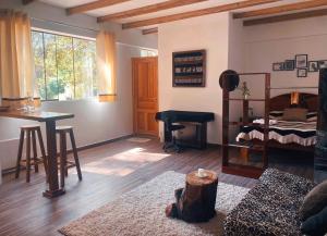 a room with a bed and a desk and a table at La Casa de Damien in Urubamba