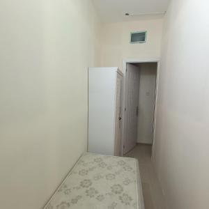 Al Basam Center في دبي: غرفة بيضاء مع ثلاجة وممر