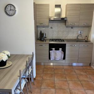 a kitchen with a stove and a table with a clock at Appartamento Antonietta-Assisi in Santa Maria degli Angeli