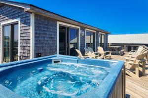 a hot tub on the deck of a house at Kinnakeet Dunes in Avon
