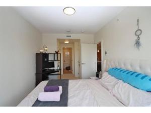 a bedroom with a large bed with purple and blue pillows at Cambie&Elizabeth Park 2BDR/Parki in Vancouver