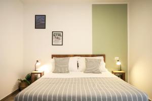 um quarto com uma cama com lençóis e almofadas listradas em Tenuta Don Alfonso em Nápoles