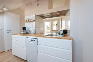 una cocina con armarios blancos y fregadero en Alte Buchbinderei Apartments, en Baden-Baden