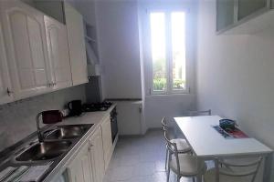 a white kitchen with a sink and a window at Cozy flat in Testaccio in Rome
