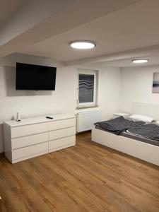 a bedroom with a bed and a flat screen tv at Home-for-you-Ferienwohnung Monteurwohnung in Buchen
