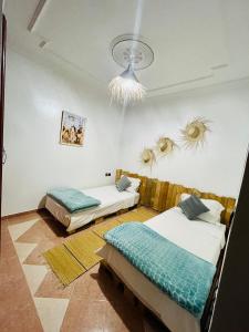 una camera con due letti e un soffitto di Tamraght White Hostel a Tamraght Ouzdar