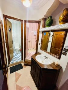 a bathroom with a sink and a shower with a toilet at Tamraght White Hostel in Tamraght Ouzdar