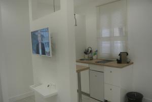 a white kitchen with a sink and a counter at Chabanon in Marseille