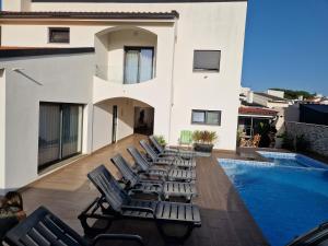 - un ensemble de chaises longues sur un balcon avec piscine dans l'établissement Casa do Martins, à Esposende