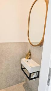 a bathroom with a sink and a mirror at Neubau stilvolle Dachgeschoss City Wohnung in Munich