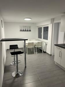 eine Küche mit einem Tisch und Stühlen im Zimmer in der Unterkunft Home-for-you-Ferienwohnung Monteurwohnung in Buchen