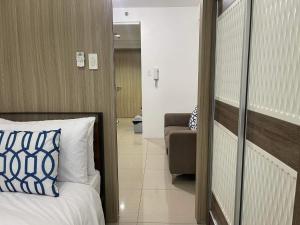 een slaapkamer met een bed en een bank in een kamer bij Shore Residences MOA C-2 1BR with balcony by darpm in Manilla