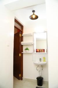 La salle de bains est pourvue d'un lavabo et d'un miroir. dans l'établissement My Cozy Home By BC, à Nairobi