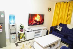 - un salon avec une télévision et un canapé dans l'établissement My Cozy Home By BC, à Nairobi