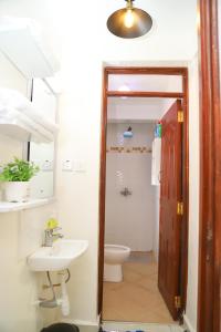 La salle de bains est pourvue d'un lavabo et de toilettes. dans l'établissement My Cozy Home By BC, à Nairobi