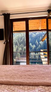 Schlafzimmer mit einem großen Fenster mit Bergblick in der Unterkunft VILA ANÐELIJA Zaovine in Lazići