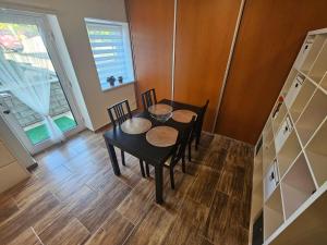 comedor con mesa, sillas y ventana en Apartmán Lovča, 