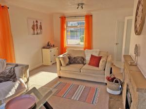 a living room with a couch and a window at Hill View House in Cheltenham