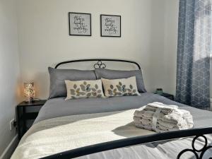 a bed with two pillows and a blanket on it at Hill View House in Cheltenham