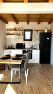 a kitchen with a table and a black refrigerator at VILA ANÐELIJA Zaovine in Lazići