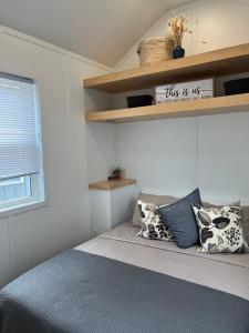 佩里的住宿－The Abb Tiny Home，卧室配有带枕头的床铺和窗户。