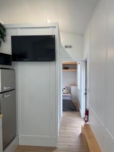 a room with a sliding door with a tv on the wall at The Abb Tiny Home in Perry