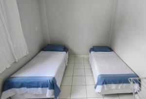 2 łóżka w małym pokoju z niebiesko-białym w obiekcie Ed Bertholi - Vista lateral do mar com garagem w mieście Serra
