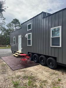 a tiny house on a trailer with a picnic table at The Big Bend Tiny Home in Perry