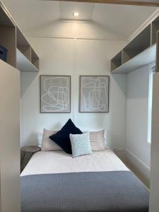a bedroom with a bed with two pictures on the wall at The Mockingbird Tiny Home in Perry