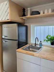 a kitchen with a refrigerator and a sink at The Mockingbird Tiny Home in Perry