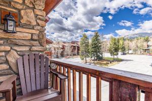 einen Holzbalkon mit einer Bank und einer Steinmauer in der Unterkunft Pine Ridge 05E in Breckenridge