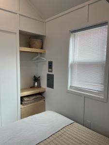 a bedroom with a bed and a window at The Sam Tiny Home in Perry