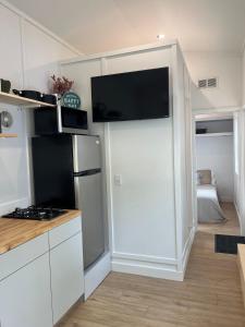 a kitchen with a refrigerator and a tv on the wall at The Sam Tiny Home in Perry