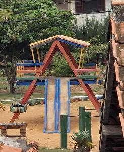 um parque infantil com uma cadeira e um baloiço em Apartamento em Cabo Frio