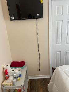 a television hanging on the wall of a bedroom at Home away from home in Laurelton