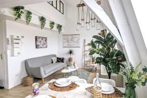 a living room with a couch and a table at Le cosy botanique in Croix
