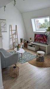 ein Wohnzimmer mit einem Sofa und einem TV in der Unterkunft Le cosy botanique in Croix