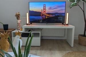 a white desk with a tv on top of it at Le cosy botanique in Croix