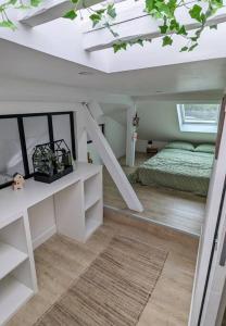 Schlafzimmer im Dachgeschoss mit einem Bett und einer weißen Decke in der Unterkunft Le cosy botanique in Croix