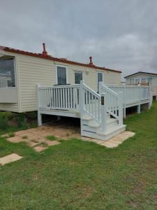 a mobile home with a porch and a white deck at Holiday Caravan in Clacton-on-Sea